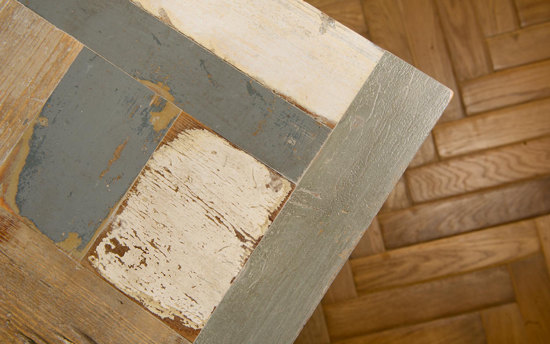 dettaglio del piano di un tavolo in legno di recupero colorato grigio bianco e azzurro
