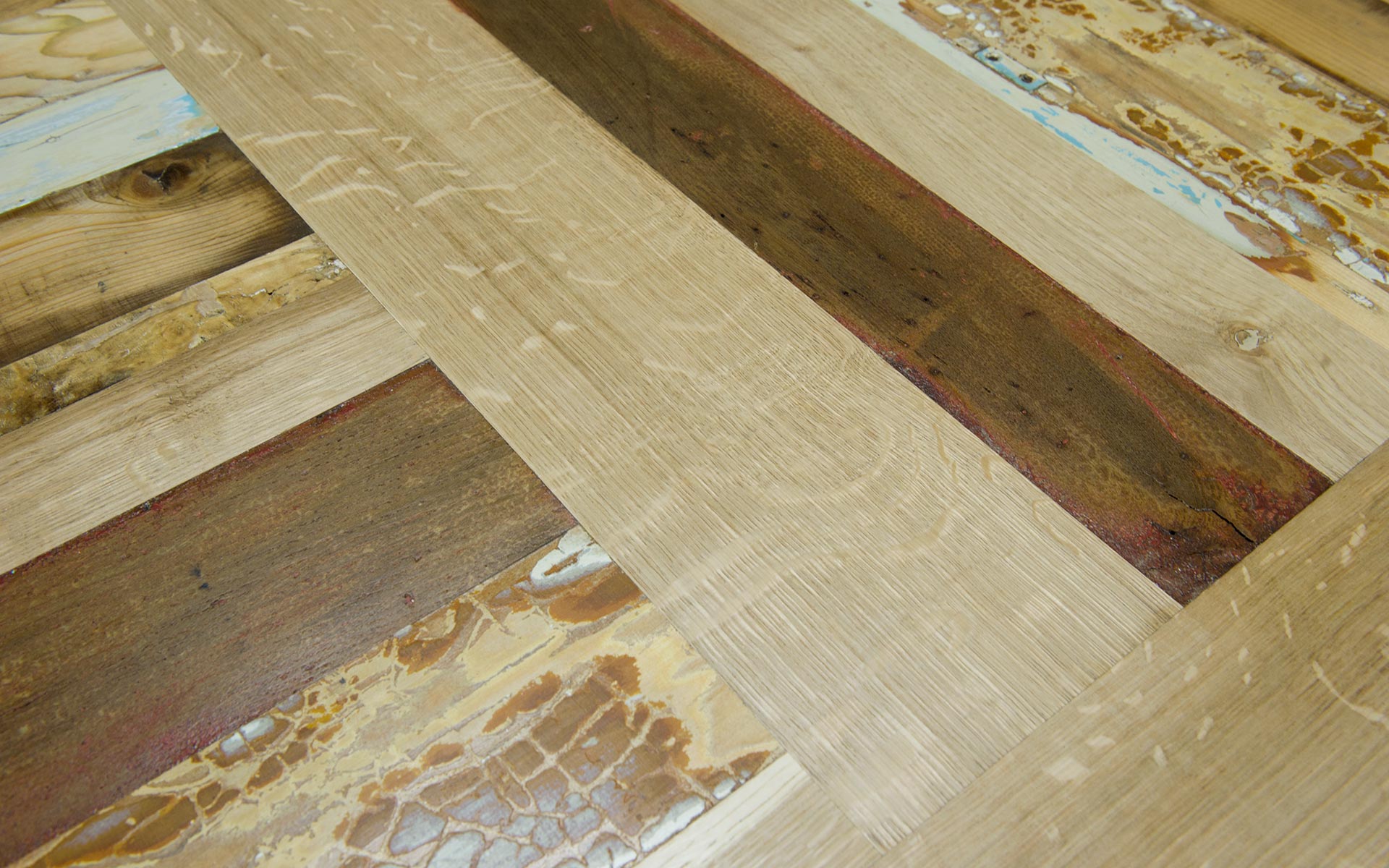 Dettaglio del piano di un tavolo in legno vecchio restaurato e rovere nuovo al naturale, con inserti di legno screpolato di recupero azzurro
